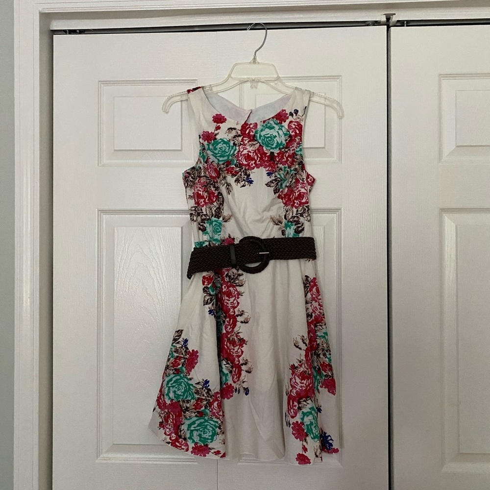 Girls sleeveless, white floral print dress with brown belt.